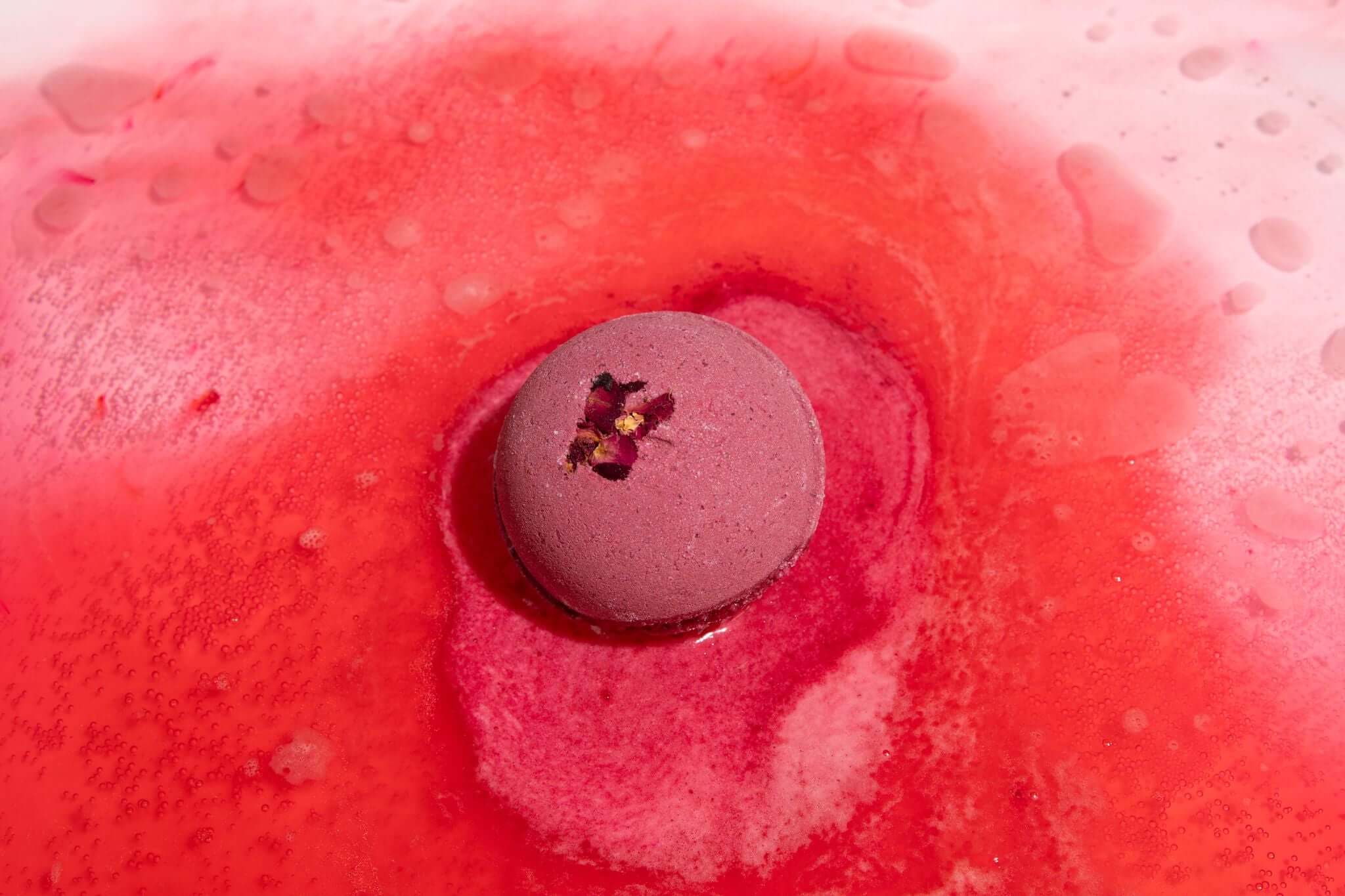 Tub Therapy | The best Wine & Roses CBD bath bomb fizzing in water, turning it a vibrant red but doesn't stain the tub.